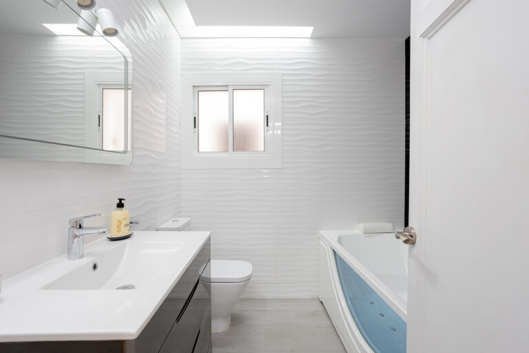 A bathroom with white walls and a tub
