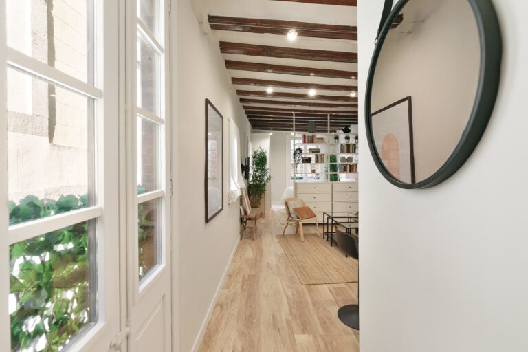 A hallway with wooden floors and white walls.