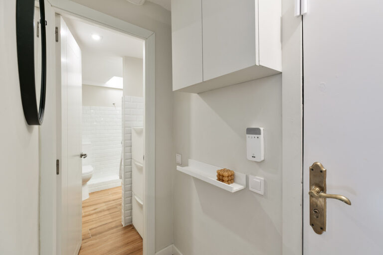A white kitchen with a wooden floor and a toilet