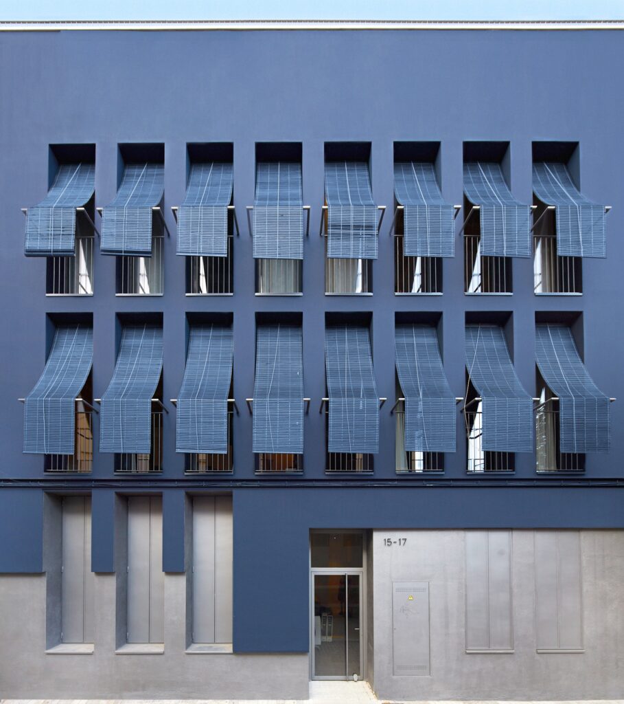 Rosich Barcelona - A building with many windows and blue fasade.