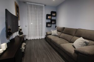 Cozy living room with sofa and shelves.