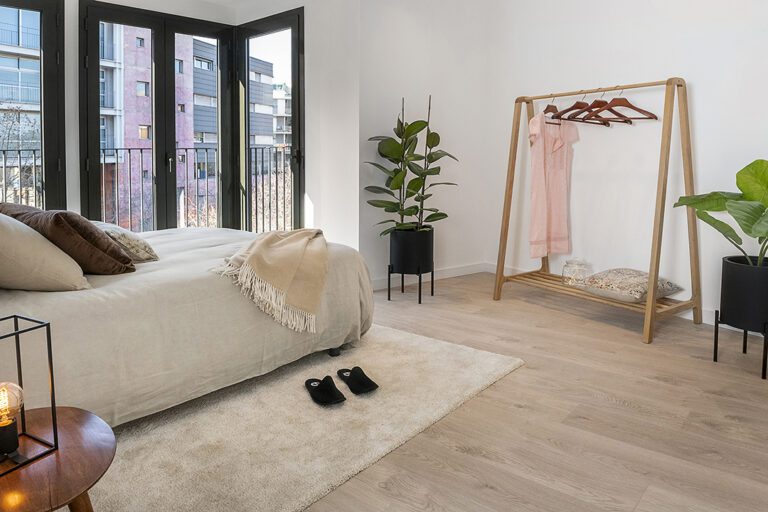 Cozy bedroom with natural light and plants.