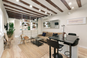 Modern living room with wooden beams and plants.
