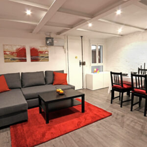 Cozy living room with red accents and furniture.