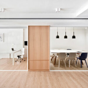 Modern office with glass walls and furniture.